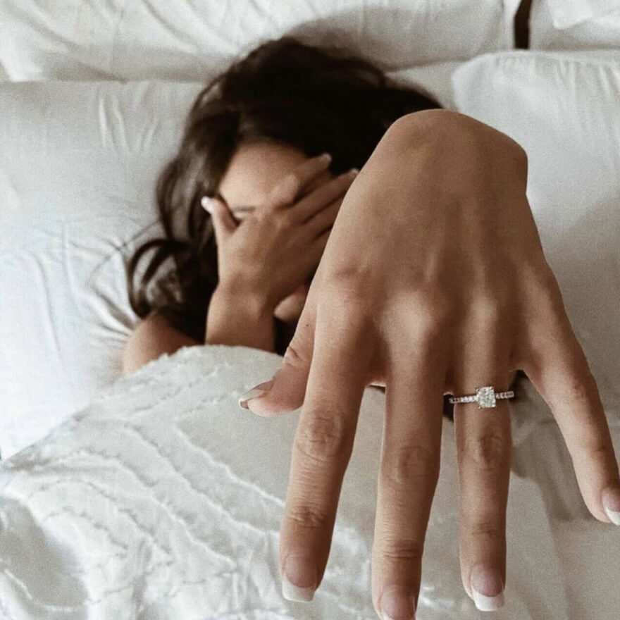 Woman in bed showing ring